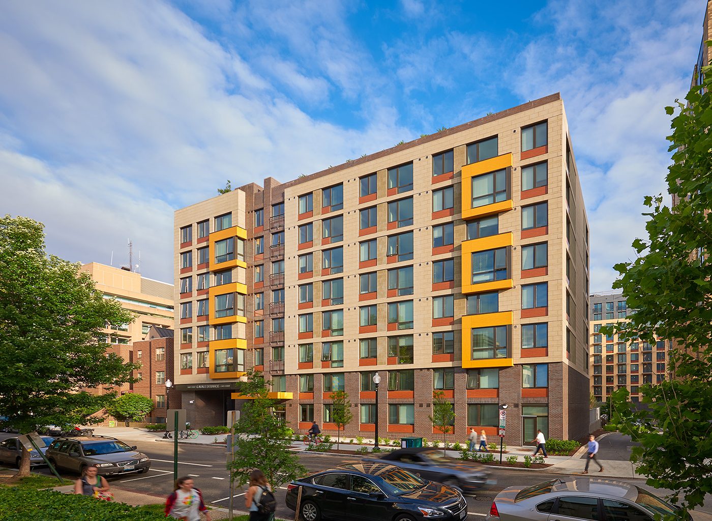 Exterior of large brick building with orange accents