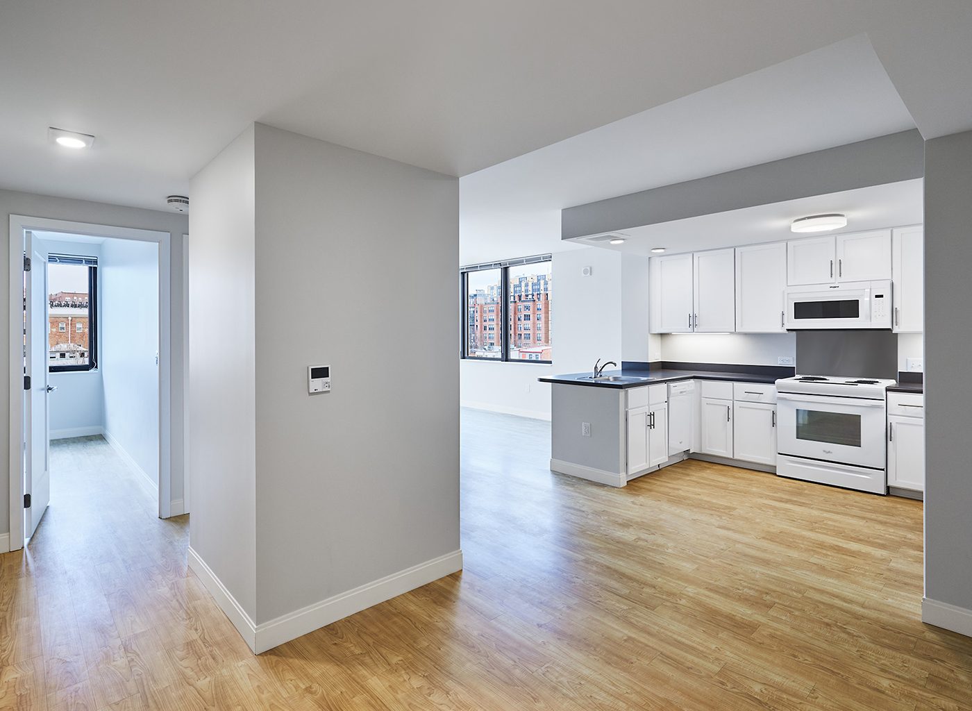 Interior of apartment complex with white walls and wood floors