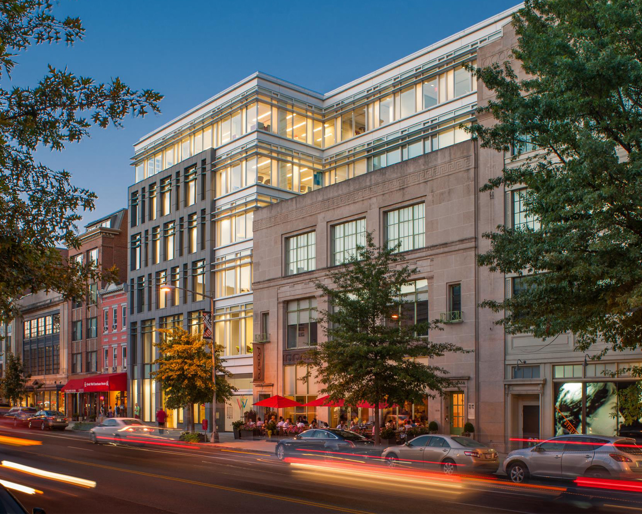 Large building with cars passing by at night