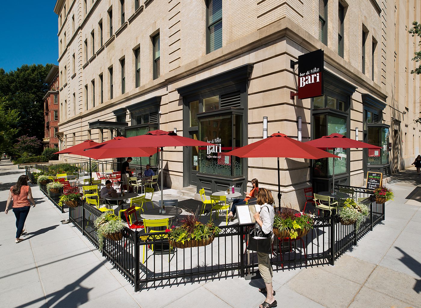 Bar outside of stone building with people walking past