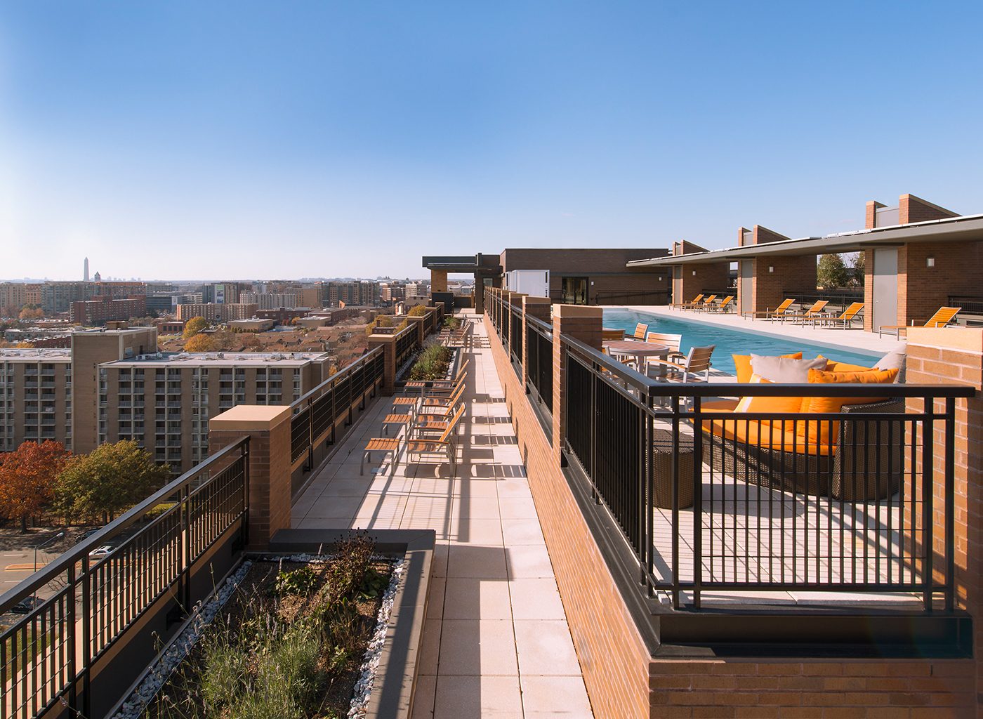 Rooftop of apartment complex with pool and deck furniture